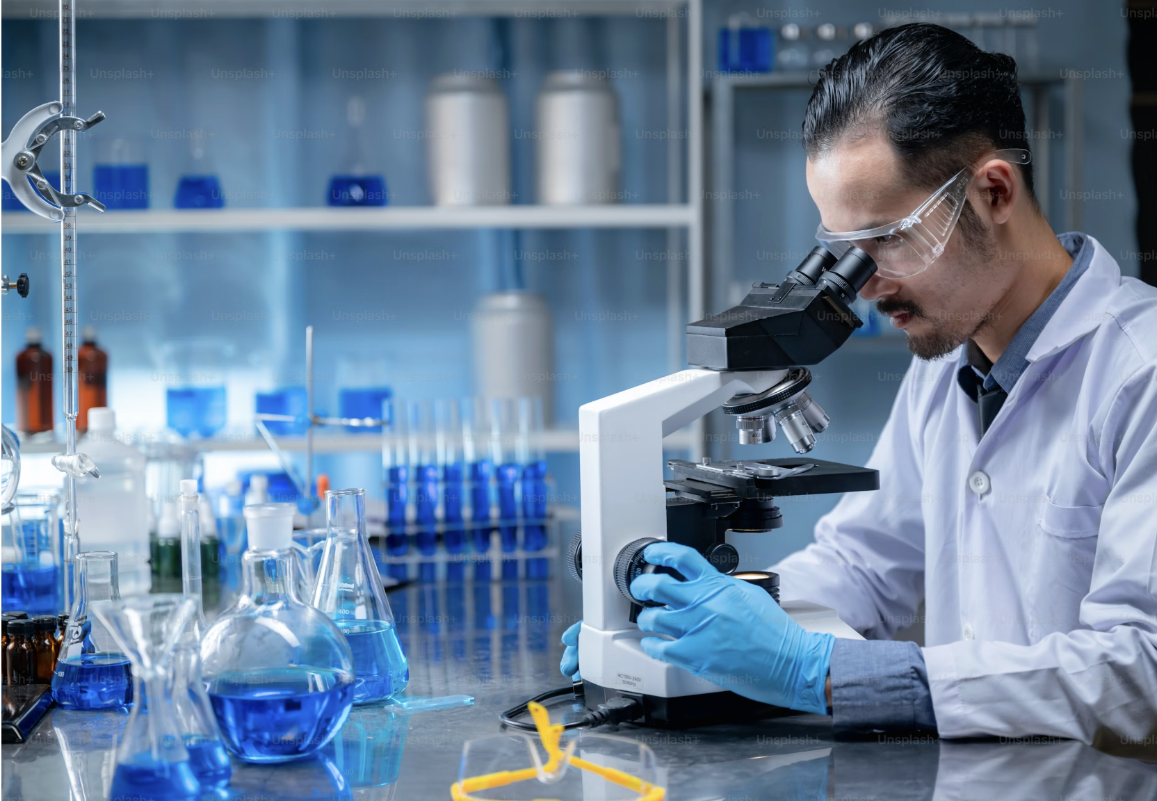 H-1B visa changes an employers guid. A man looking through a microscope