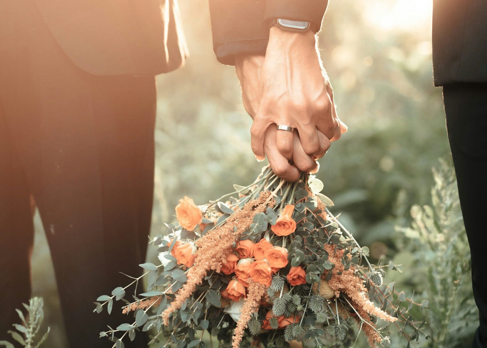 Gay LGBTQ + Couple holding hands with bouquet. Marriage Visas & Green Cards 2026