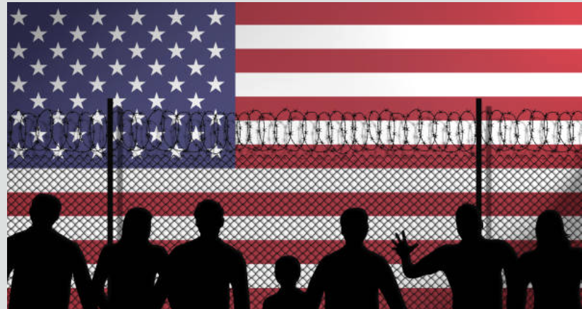 Green card holders going abroad Rules just changed for you. Picture of people on the other side of a barbed wire fence looking at a US flag